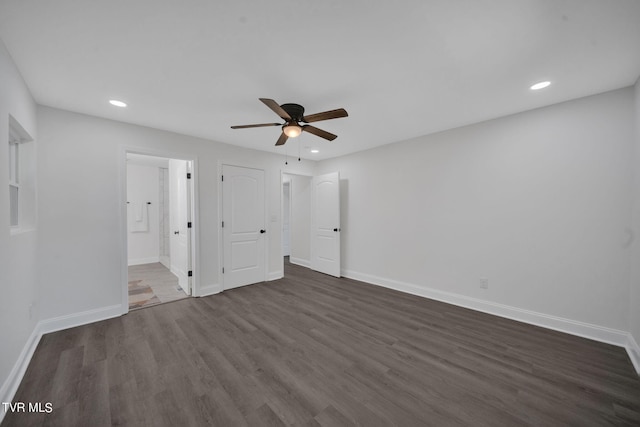 unfurnished bedroom with recessed lighting, baseboards, dark wood-style floors, and ensuite bathroom