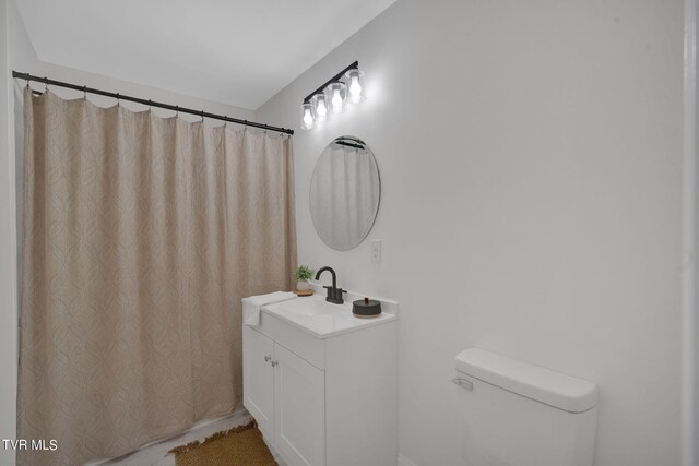 full bath with a shower with shower curtain, toilet, and vanity