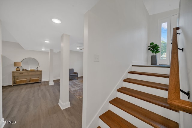 stairway with recessed lighting, wood finished floors, and baseboards