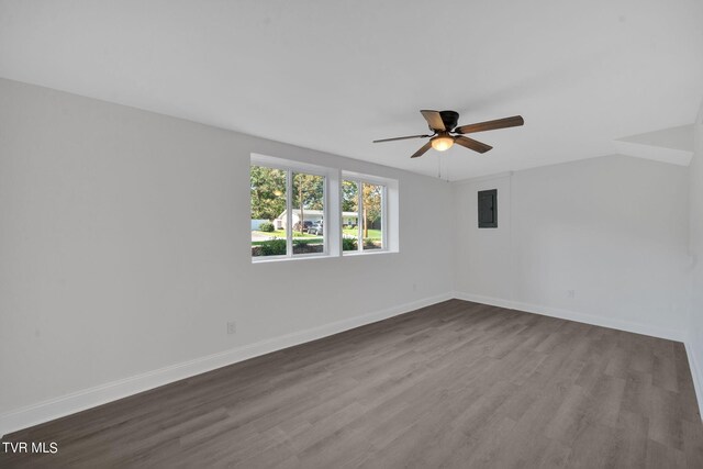 spare room featuring dark wood finished floors, a ceiling fan, and baseboards