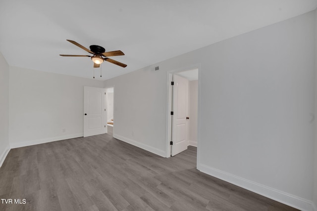 spare room featuring visible vents, wood finished floors, baseboards, and ceiling fan