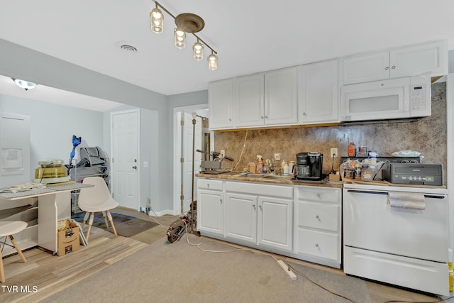 kitchen with decorative backsplash, white microwave, dishwashing machine, and white cabinetry