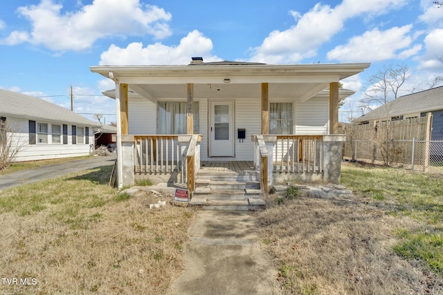 view of front of property with a porch and fence