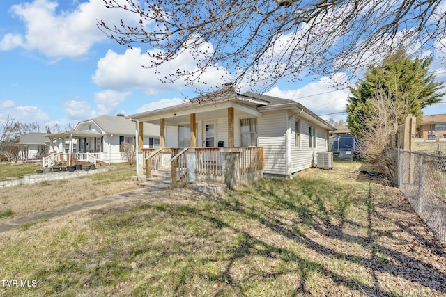 view of front of property with a porch, fence, and central AC