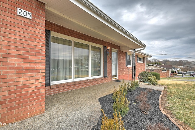 entrance to property featuring brick siding