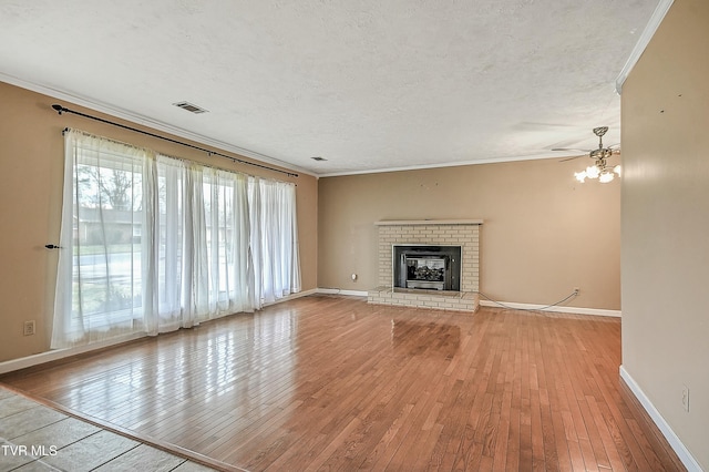 unfurnished living room with hardwood / wood-style floors, crown molding, and visible vents