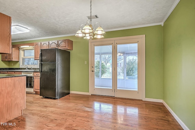 kitchen featuring dark countertops, light wood-type flooring, freestanding refrigerator, and a textured ceiling