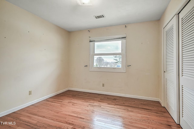 unfurnished bedroom with visible vents, baseboards, a closet, and light wood-style flooring