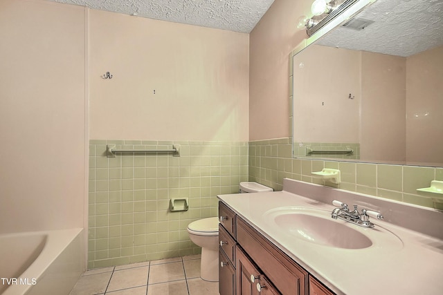 full bath featuring a tub, a textured ceiling, tile patterned floors, toilet, and tile walls