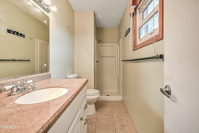 bathroom with tile patterned flooring, a shower stall, toilet, vanity, and a textured ceiling