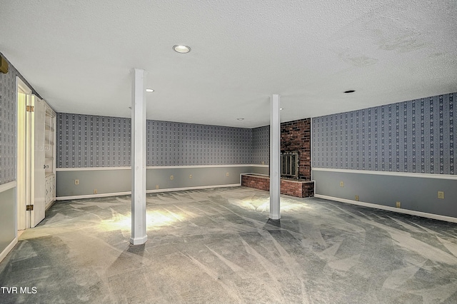 finished basement featuring a wainscoted wall, a textured ceiling, wallpapered walls, and carpet floors