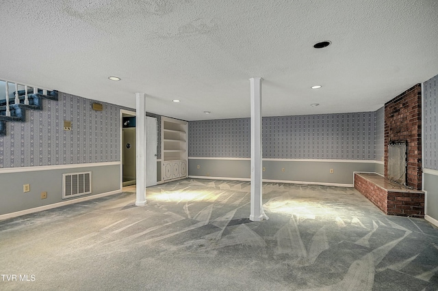 finished basement featuring visible vents, carpet floors, and wallpapered walls