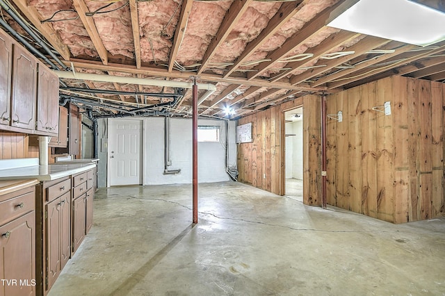 basement featuring wood walls