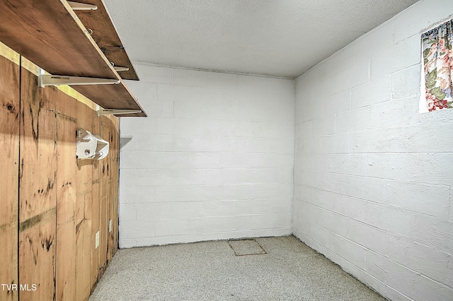 spare room featuring concrete block wall