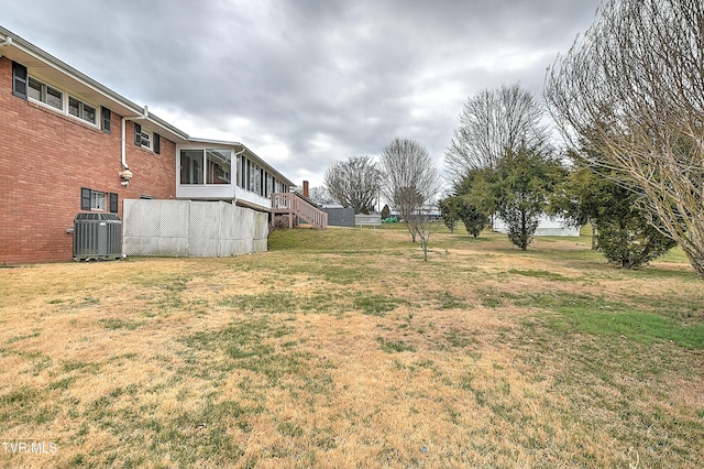 view of yard featuring stairway, central AC, and a sunroom