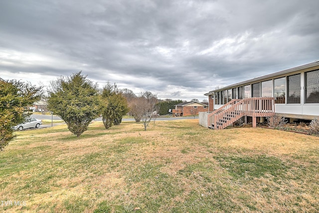 view of yard with stairs and a sunroom