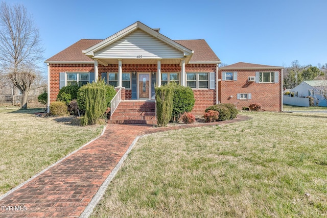 view of front of house with a front yard, brick siding, and a shingled roof