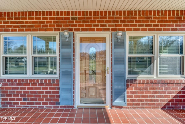 property entrance featuring brick siding