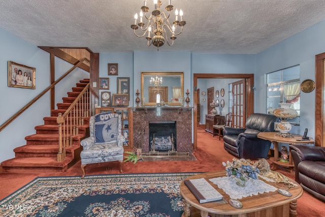 carpeted living room with stairway, a notable chandelier, a fireplace, and a textured ceiling