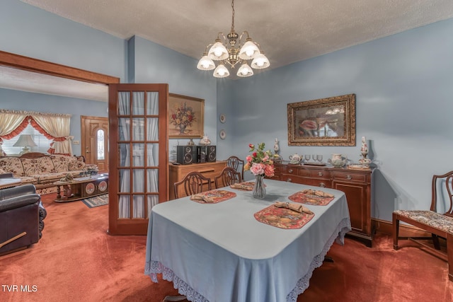 dining space with a textured ceiling, carpet floors, and a chandelier