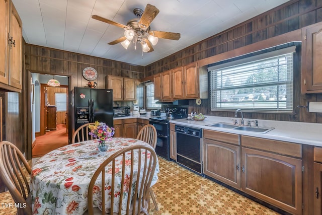 kitchen with a wealth of natural light, black appliances, light countertops, and a sink