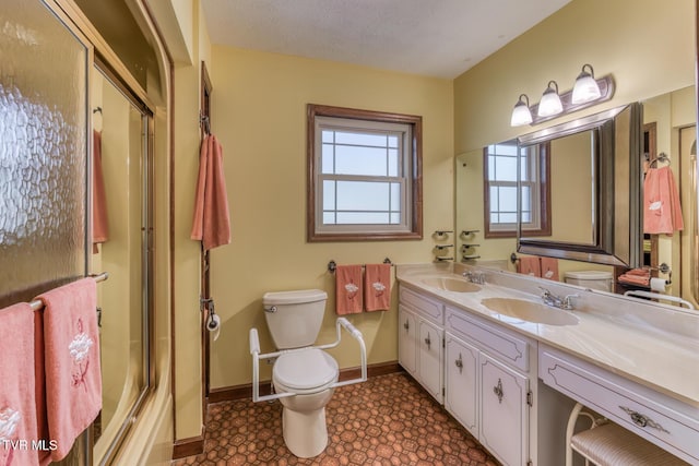 full bathroom with an enclosed shower, toilet, a textured ceiling, baseboards, and vanity