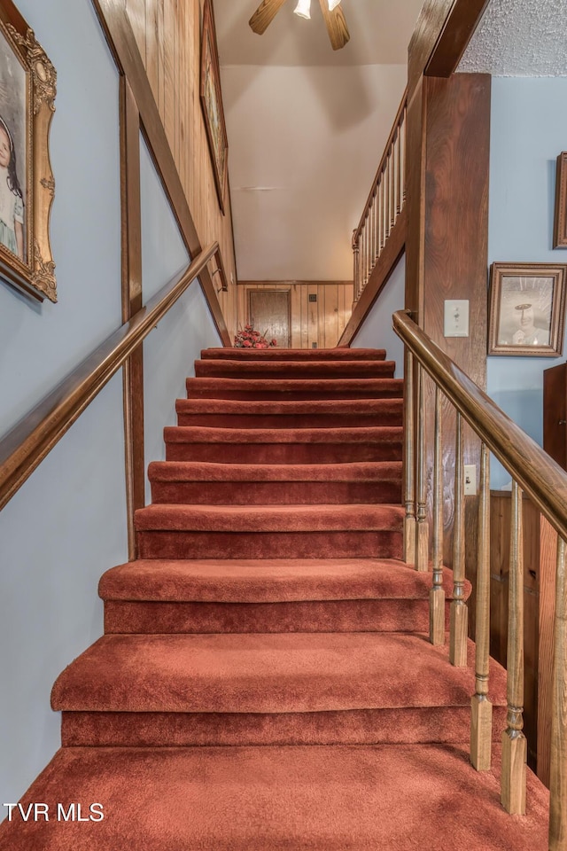 stairs featuring ceiling fan