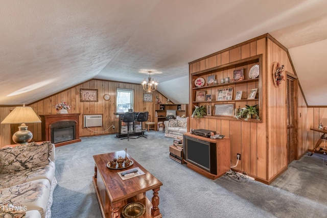 carpeted living room featuring a textured ceiling, a glass covered fireplace, a wall unit AC, wood walls, and vaulted ceiling