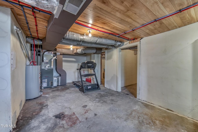 unfinished basement with visible vents, wooden ceiling, and water heater