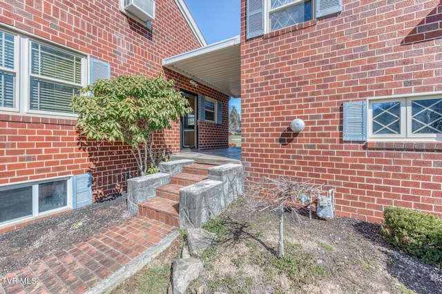 view of exterior entry featuring brick siding