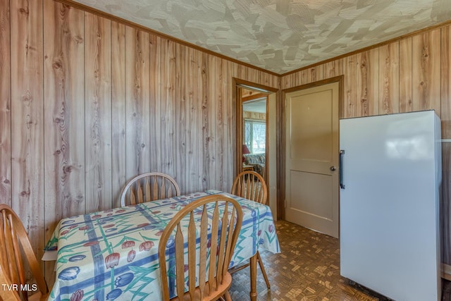 dining room with wood walls and ornamental molding