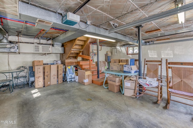 basement with electric panel, visible vents, and stairs