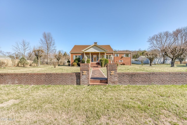 view of front of house featuring brick siding, covered porch, and a front yard