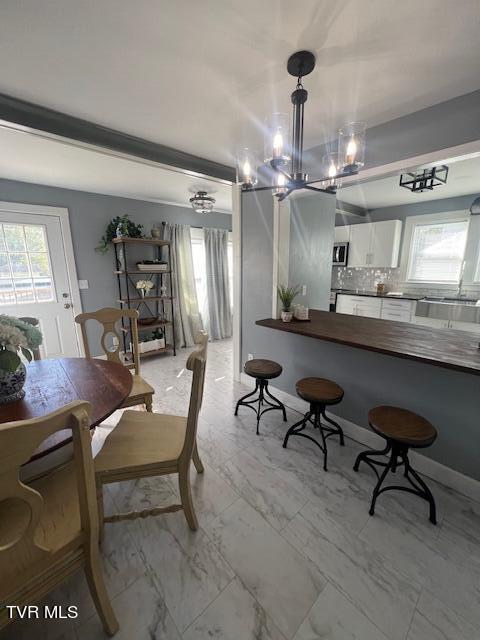 dining area featuring baseboards and marble finish floor