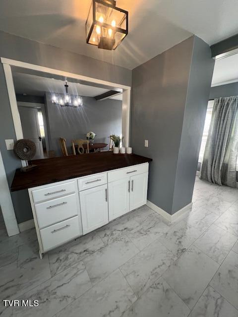 bathroom with baseboards, marble finish floor, and vanity