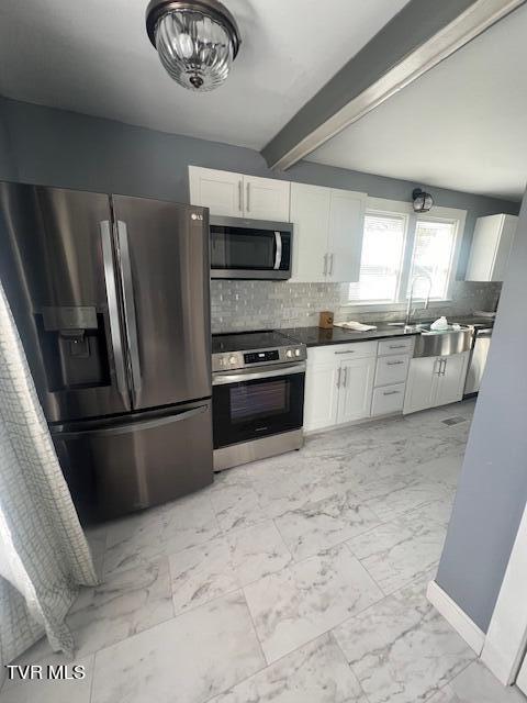 kitchen with white cabinetry, decorative backsplash, marble finish floor, and appliances with stainless steel finishes