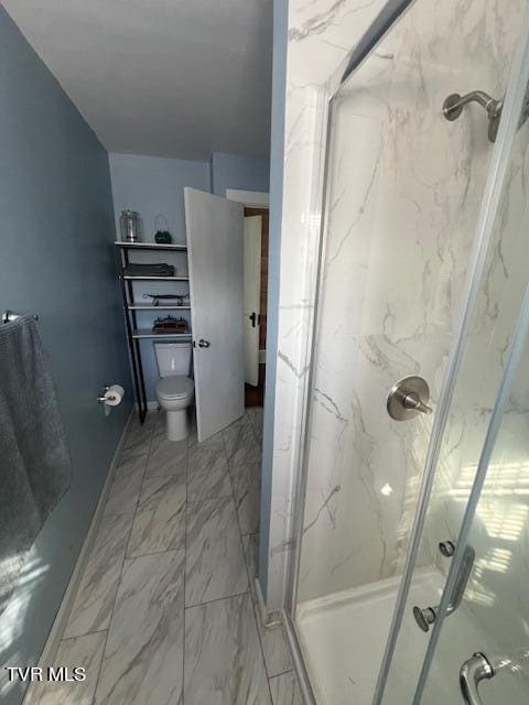 bathroom featuring a marble finish shower, marble finish floor, toilet, and baseboards