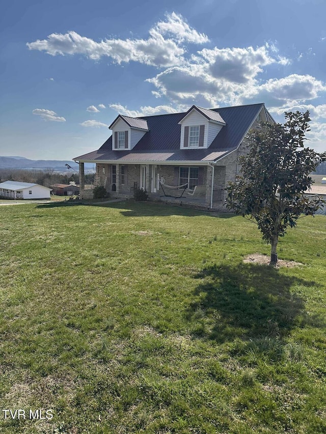 view of front of house featuring stone siding, a porch, metal roof, and a front yard