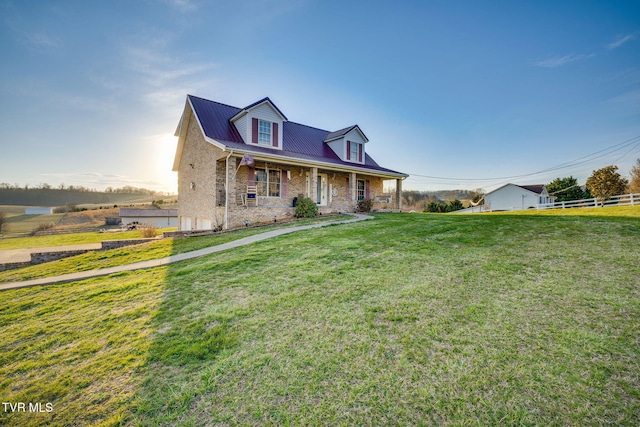 cape cod home featuring brick siding and a front lawn