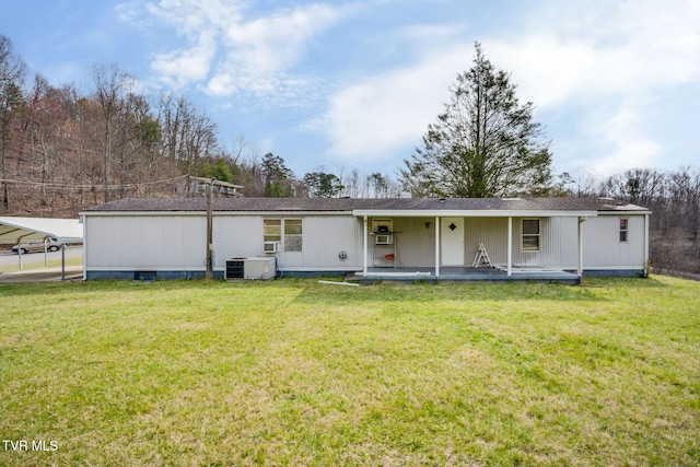 rear view of property with a detached carport, central air condition unit, and a lawn