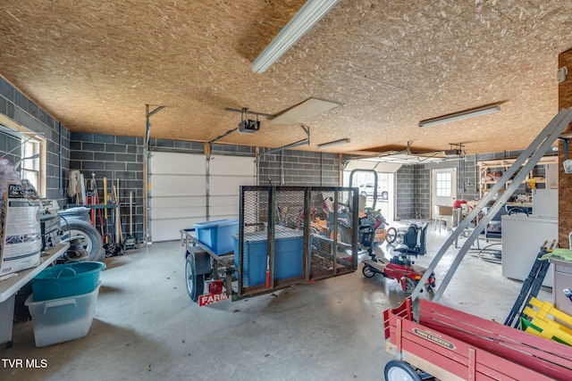 garage with concrete block wall and a garage door opener