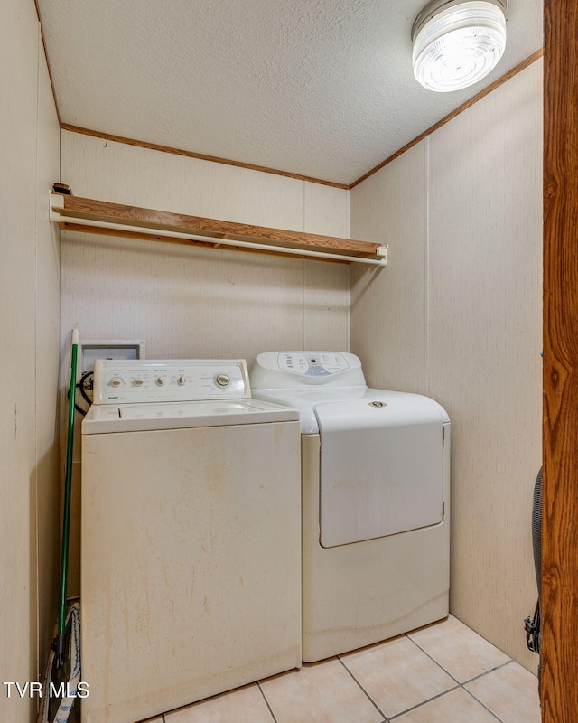 laundry area with laundry area, light tile patterned floors, separate washer and dryer, and a textured ceiling