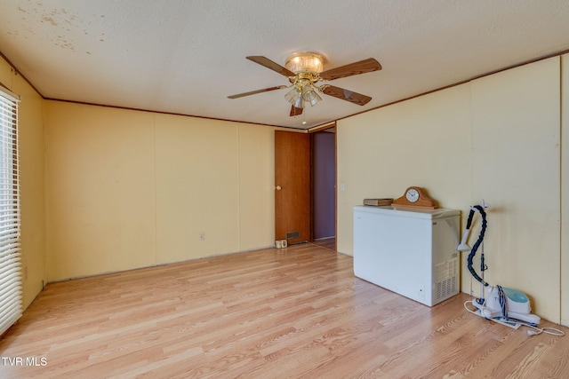 unfurnished room featuring visible vents, crown molding, ceiling fan, light wood-style flooring, and a textured ceiling