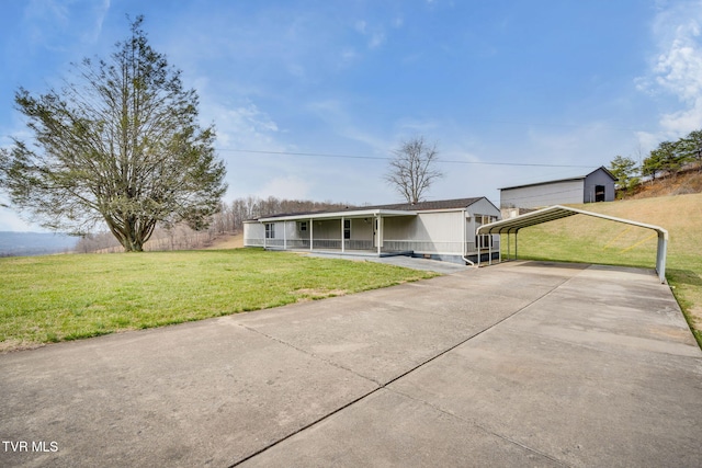 view of front of home featuring a detached carport, a porch, driveway, and a front yard