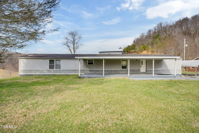 back of property with a patio area and a lawn