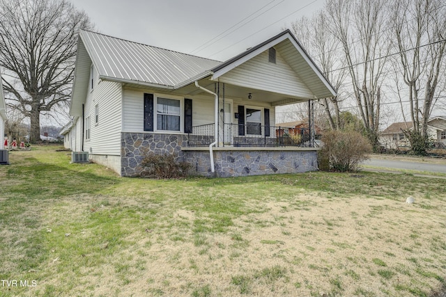 view of front of home with central air condition unit, a porch, metal roof, and a front yard