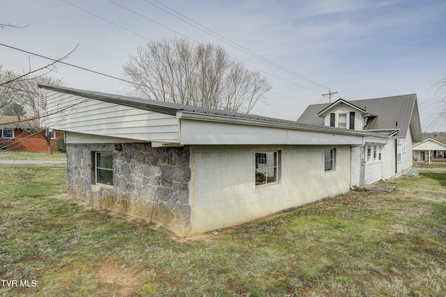 view of home's exterior featuring a lawn and metal roof