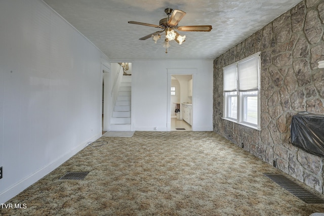 interior space with visible vents, carpet floors, arched walkways, ceiling fan, and a textured ceiling