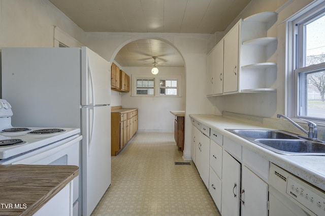 kitchen featuring white appliances, a ceiling fan, light floors, open shelves, and a sink