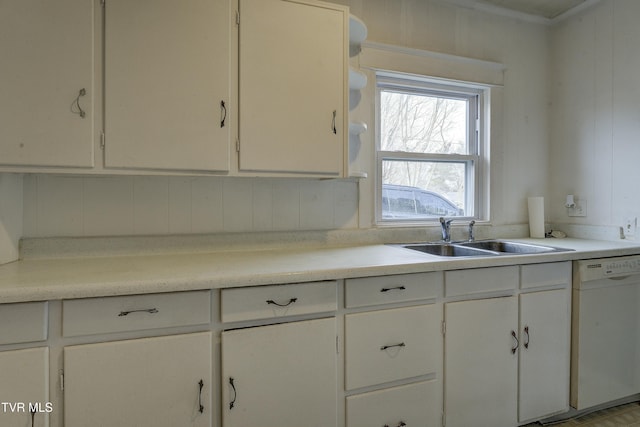 kitchen featuring white cabinetry, light countertops, white dishwasher, and a sink